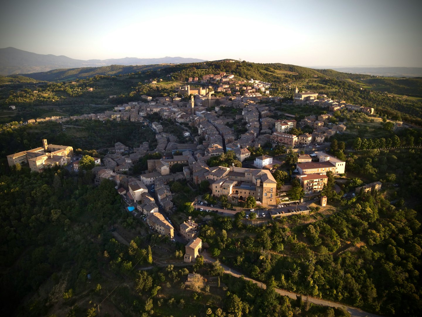 Antica città in pietra con tetti in terracotta siede su una collina.